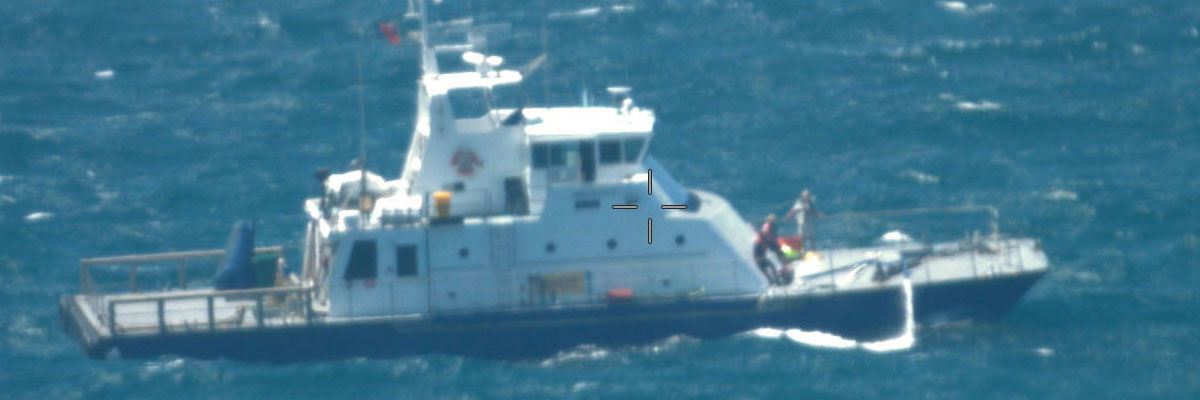 Challenger aircraft dropping equipment to a flooded catamaran