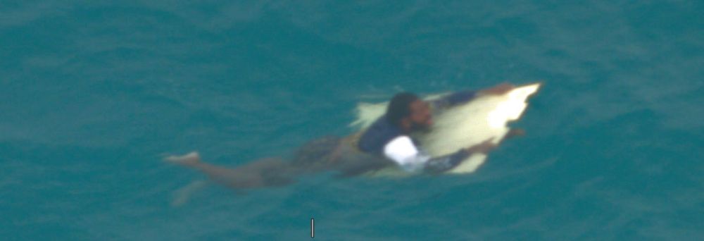 Man clinging to flotsam in the water