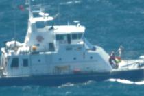 Challenger aircraft dropping equipment to a flooded catamaran
